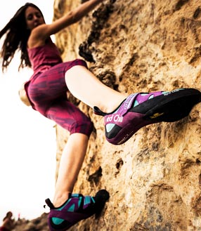 Ein Frau klettert am Felsen 